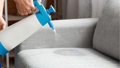Pano a absorver uma mancha num sofá de tecido claro